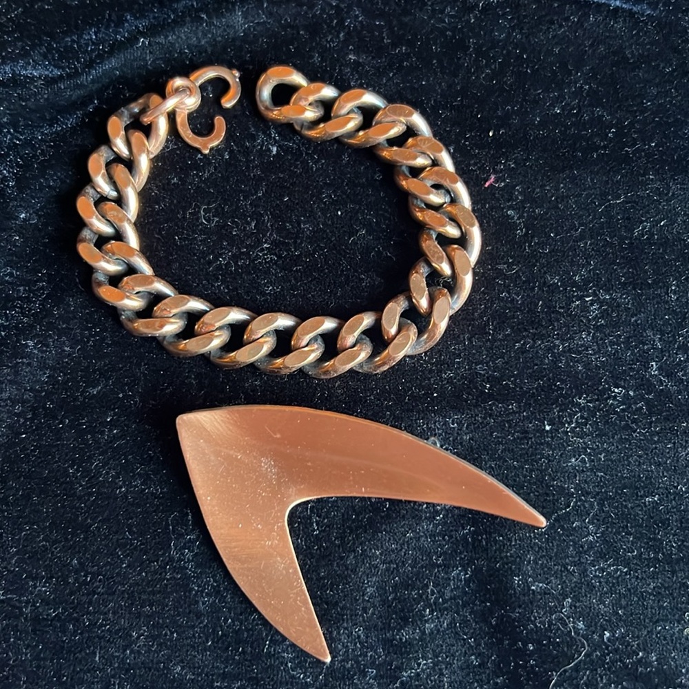 Copper? Or copper colored pin and bracelet.